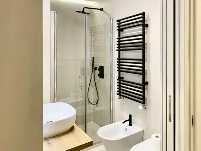a white bathroom with a sink and a shower at DaliTourism - Nazionale Charme in Rome