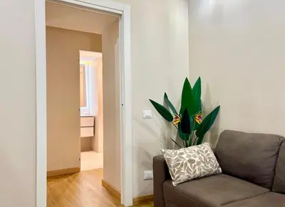 a living room with a couch and a plant at DaliTourism - Nazionale Charme in Rome