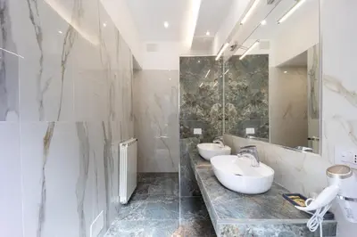 a bathroom with two sinks and a mirror at Caruso Regal House in Rome