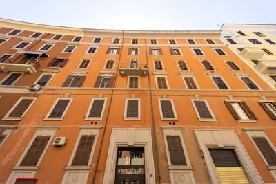 a tall orange building with lots of windows at Caruso Regal House in Rome