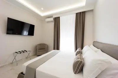 a bedroom with a bed with a television on the wall at Caruso Regal House in Rome