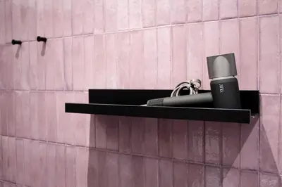 a black shelf with a microphone on a pink wall at Re di Roma Luxury Suite in Rome