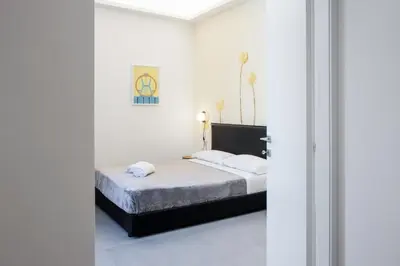 a bedroom with a bed and white walls at Re di Roma Luxury Suite in Rome