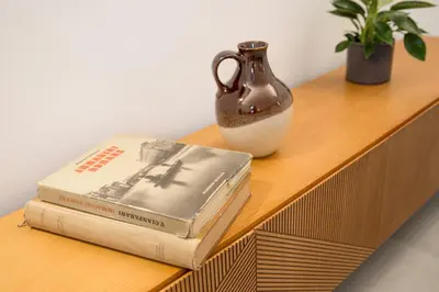 two books and a vase on a wooden shelf at Re di Roma Luxury Suite in Rome