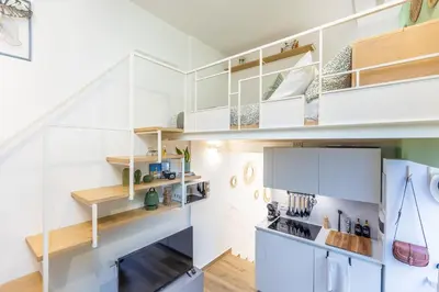 a kitchen with white cabinets and a staircase at Fabiè Trastevere in Rome