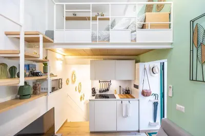 a small kitchen with white cabinets and a green wall at Fabiè Trastevere in Rome