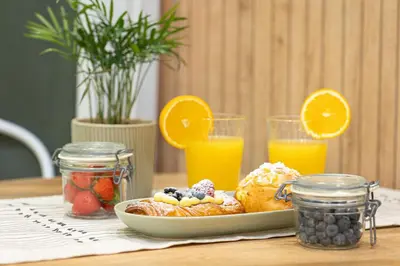 a plate of breakfast food on a table with orange juice at Fabiè Trastevere in Rome