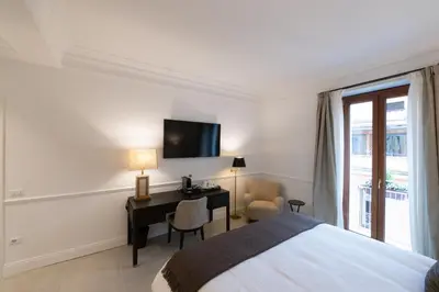 a bedroom with a bed and a desk and a television at La Scalinata - Boutique Guest House in Rome