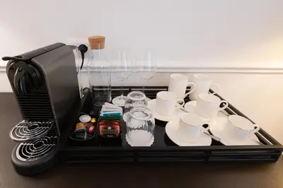 a tray with cups and cups and a coffee maker at La Scalinata - Boutique Guest House in Rome