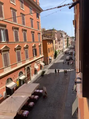 an empty city street with buildings and tables and people walking at Appartamento storico borgo Pio in Rome