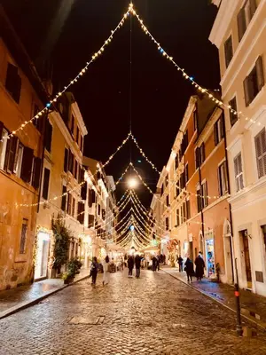 a street with christmas lights and people walking down the street at Appartamento storico borgo Pio in Rome