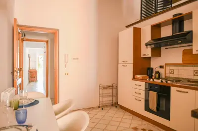 a kitchen with white cabinets and a table and chairs at Appartamento storico borgo Pio in Rome