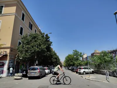 a person riding a bike down a city street at Crystal Domus in Rome