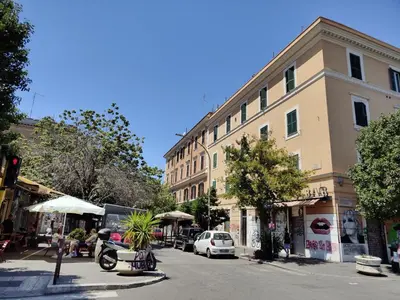 a street with a building and cars parked on the street at Crystal Domus in Rome