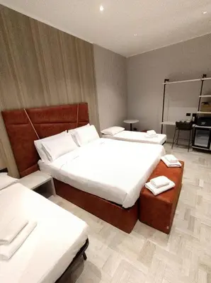 a hotel room with two beds and a table at Crystal Domus in Rome