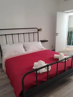 a bedroom with a large bed with a red blanket at La Casetta Monteverde in Rome