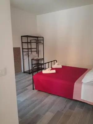 a bedroom with a bed with a red blanket at La Casetta Monteverde in Rome