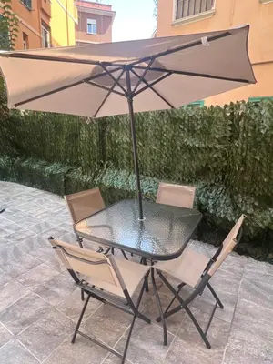 a table and chairs with an umbrella on a patio at La Casetta Monteverde in Rome