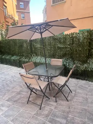 a table and two chairs with an umbrella at La Casetta Monteverde in Rome