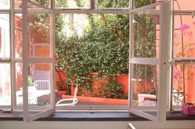 a window view of a garden with a bush at Deco Garden Apartment Trastevere in Rome