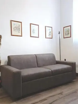 a couch in a living room with two pictures on the wall at Apartment B4 in the center of Rome WiFi and AC in Rome