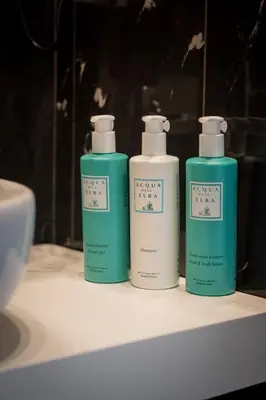 three bottles of soap sitting on a bathroom counter at The Place 217 in Rome