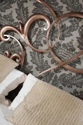a bed with a metal head board with a wall at The Place 217 in Rome