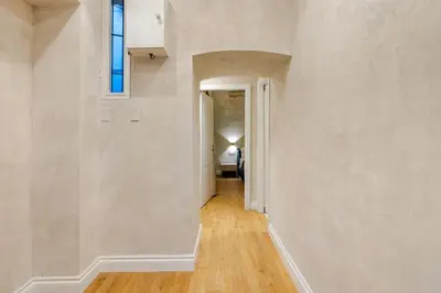 a hallway with white walls and wooden floors and a window at The Place 217 in Rome