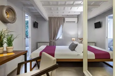 a hotel room with two beds and a desk at The Spanish Suite Piazza di Spagna in Rome