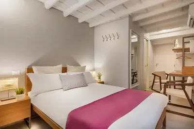 a bedroom with a large white bed and a table at The Spanish Suite Piazza di Spagna in Rome