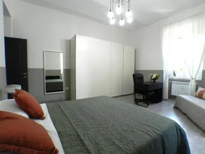 a bedroom with a bed and a couch and a mirror at Giuseppe Apartment in Rome