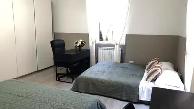 a bedroom with two beds and a desk and a chair at Giuseppe Apartment in Rome