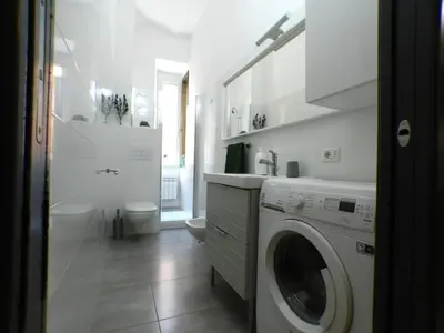 a white bathroom with a washing machine in it at Giuseppe Apartment in Rome