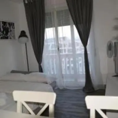 a bedroom with two beds and a large window at Domus Romuli in Rome