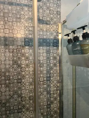 a shower with a glass door with two soap bottles at Casa vacanze San Lorenzo in Rome