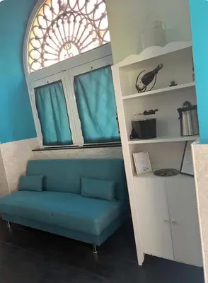 a living room with a blue couch in front of a window at Casa vacanze San Lorenzo in Rome