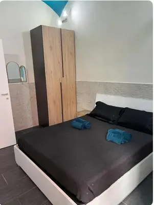 a bed with two blue pillows on it in a room at Casa vacanze San Lorenzo in Rome