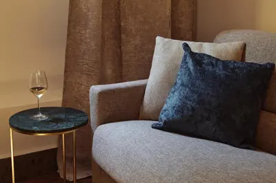 a glass of wine on a table next to a chair at Domus Duca Claudius I Classy Vatican Apartment With Private Garden in Rome