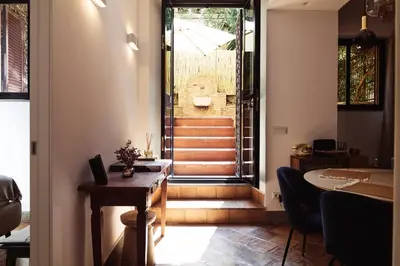 a room with a hallway with a table and stairs at Domus Duca Claudius I Classy Vatican Apartment With Private Garden in Rome