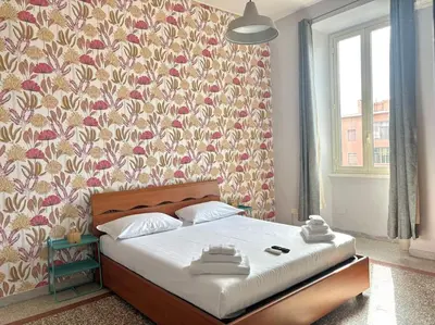 a bedroom with a bed with a floral wallpaper at Scalo Home in Rome