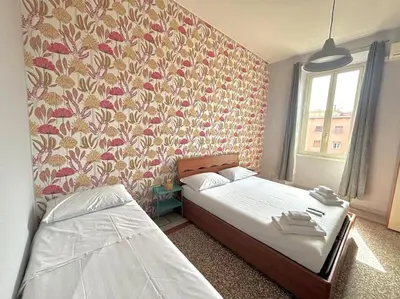 a bedroom with two beds and a floral wallpaper at Scalo Home in Rome