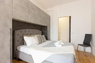 a bedroom with a large white bed and a chair at Sweet Maya Home in Rome