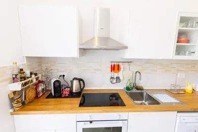 a kitchen with white cabinets and a sink at Vespasiano 49 in Rome