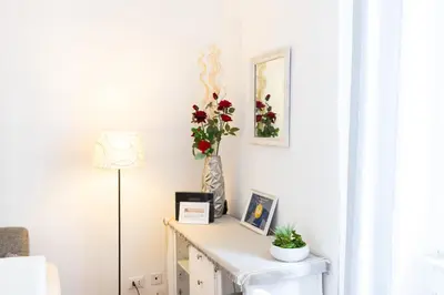 a room with a table with a vase of flowers at Vespasiano 49 in Rome