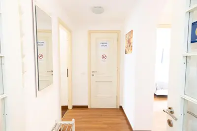 a hallway with a mirror and a white door at Vespasiano 49 in Rome