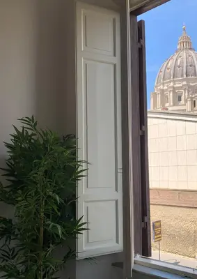 an open door with a plant in front of a window at Maison Cavalleggeri in Rome