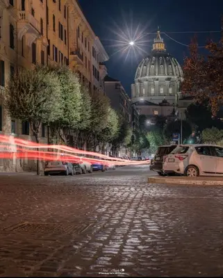 a city street at night with a domed building at Maison Cavalleggeri in Rome