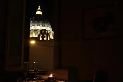 a lit candle on a table in a dark room with the capitol building at Maison Cavalleggeri in Rome