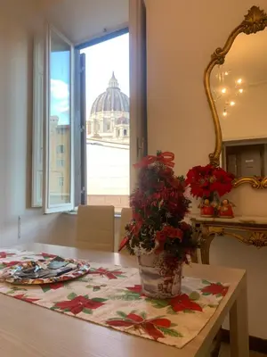 a dining room table with a vase of flowers on it at Maison Cavalleggeri in Rome