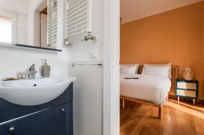 a bathroom with a sink and a bed at Da Giorgio e Teresa - Attico con terrazza a Piazza del Popolo in Rome